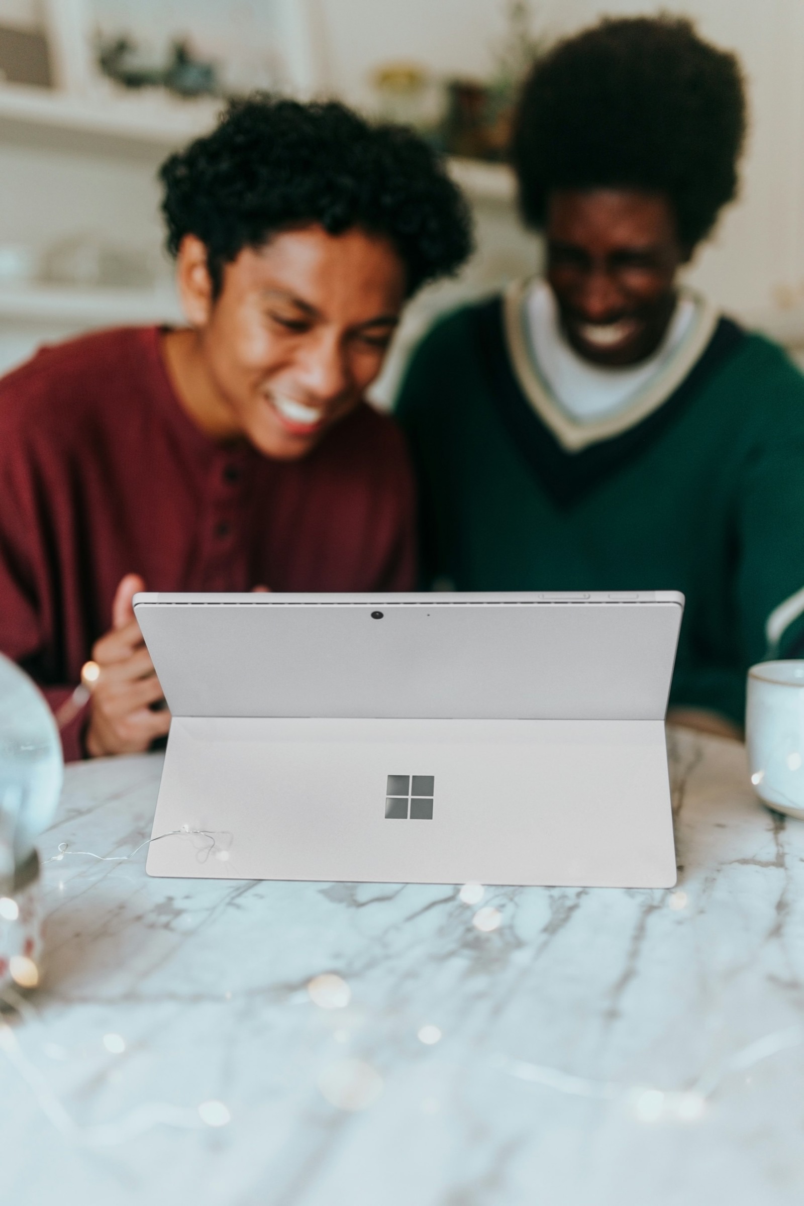 Two friends laughing together at a laptop